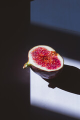 Cutted Fresh figs with shadows on dark and white background. contrast shadow fruitf lat lay, top...