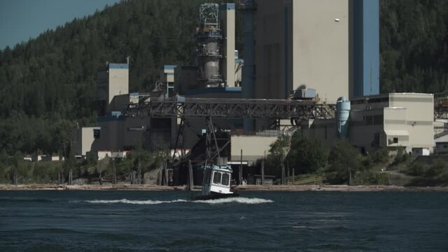 Logging Tug Motors Up River Past Pulp Mill