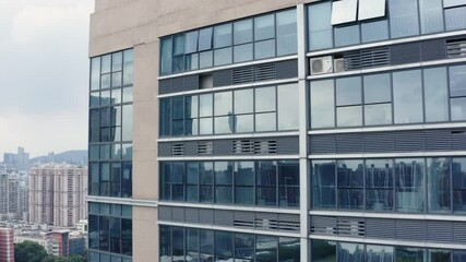 Guangzhou tower reflected in office buildings panoramic windows.
