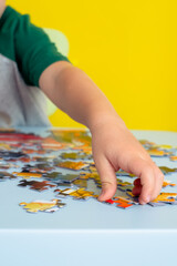 close up of a child's hand holding a puzzle. Early learning.