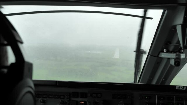 Point of View Airline Pilot Landing Aircraft in Bad Rainy Weather.