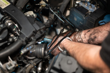 Fototapeta na wymiar Senior Mechanic working on engine bay repairing a oil leak in home garage