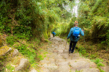 Obraz premium Hikers on the Inca trail near the Puyupatamarca archological site, Peru. Many of the stones in the trail were hand carved by ancient peruvians.