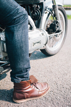 Close up of a motorsyclists boot and jeans while sitting on his motor