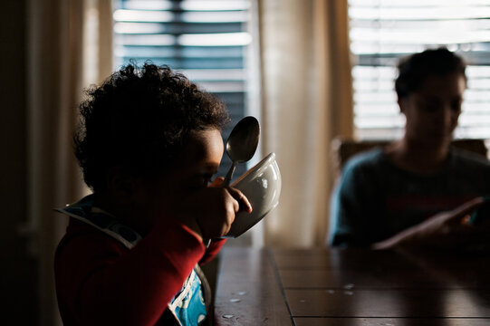toddler boy slurping his milk from a bowl