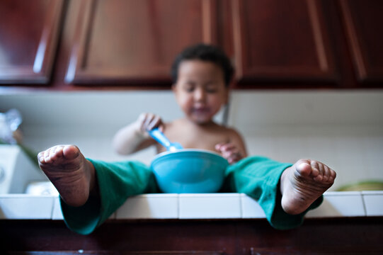 Toddler eating cereal on the kitchen counter