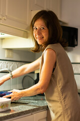 Woman doing chores in the kitchen, cleaning strawberries