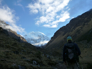 Hikers in the shadows on the Salkantay trek in Peru, with snow capped mountains in the distance