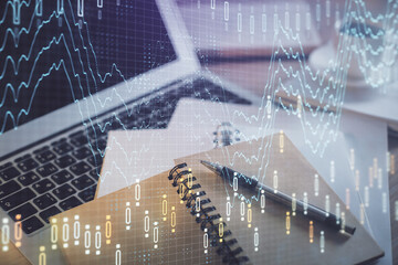 Double exposure of financial chart drawing and desktop with coffee and items on table background. Concept of forex market trading
