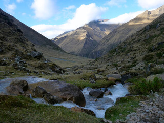 A scenic view of the rocky and mountainous terrain along the Salkantay trek in Peru, with a river in the foreground