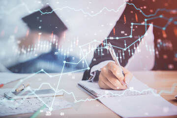 Double exposure of forex chart drawing over people taking notes background. Concept of financial analysis