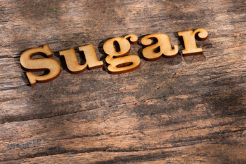 Word sugar in wooden letters - text space