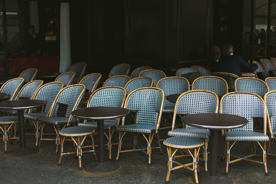 Rows of empty blue chairs at bistro in Paris