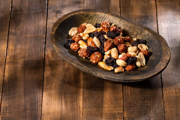 Mixed dried fruits in the wooden bowl - Wooden background