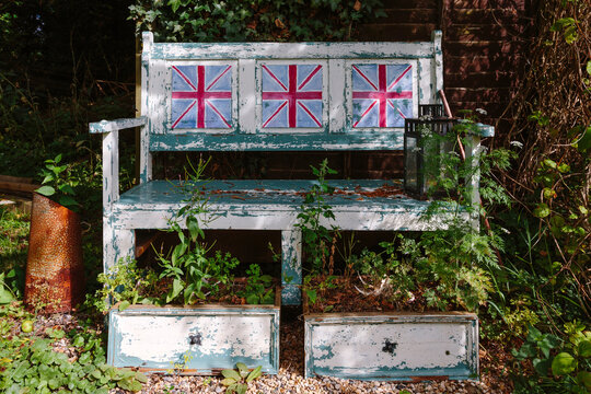 Old rustic garden bench with three paintings of the national flag of the United Kingdom