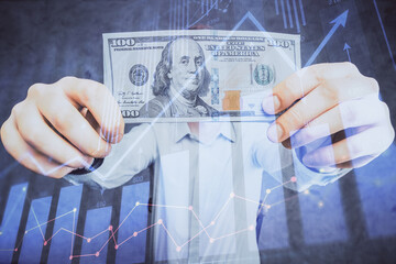 Multi exposure of financial graph drawing hologram and USA dollars bills and man hands. Analysis concept.