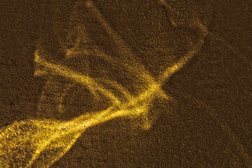 Reflected sun glare on a golden rough painted surface in the form of a plexus of lines,...