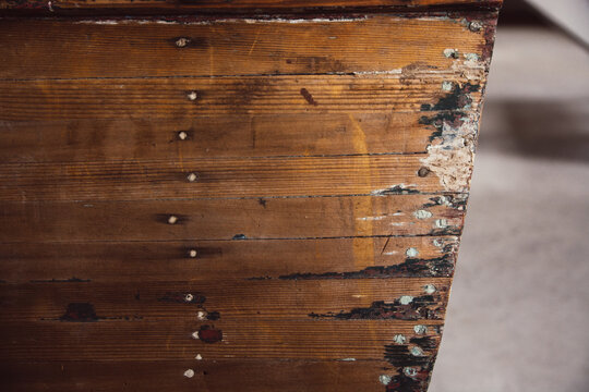 Front side of an old fishing wooden row boat on display in a museum