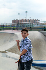 Young hispanic boy with skateboard at a skate park