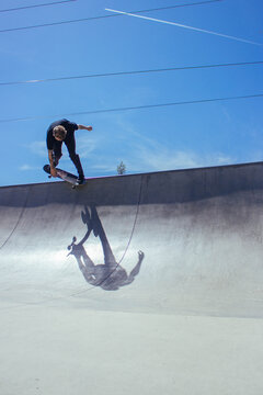 A young man performs a skateboard trick on a ramp
