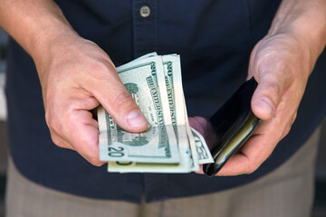 Man putting his money in his wallet