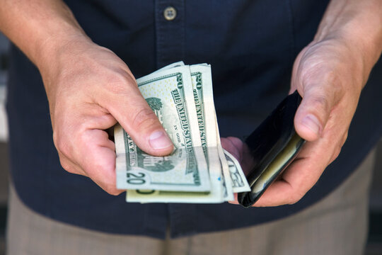 Man putting his money in his wallet