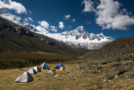 Tents in a high meadow with high altitude mountains