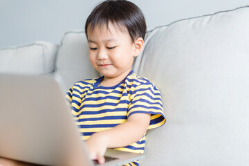 Asian toddler boy student study online learning online education video call zoom teacher.Happy boy learn english online with laptop at home.New normal.Covid-19 coronavirus.Social distancing.stay home.