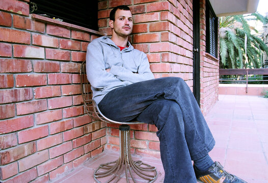 Portrait of a Young Man Sitting at His Porch