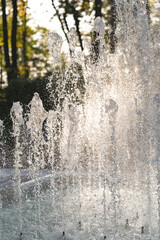Close up of splash of water in fountain at sunset. 