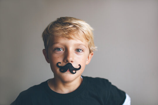 kid wearing a fake mustache