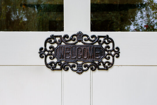 Antique welcome sign on white door