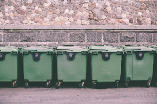 many green plastic garbage bins