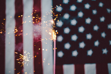 Ignited sparkler in front of the American flag