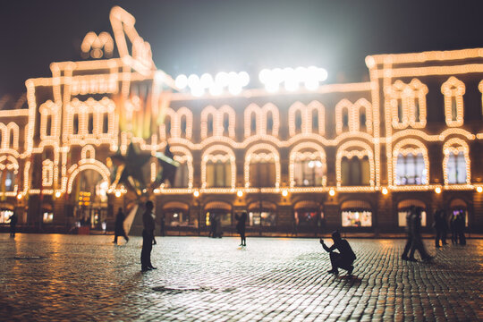 Tourists making photo at night in front of Moscow Upper Trading Rows (""GUM"")