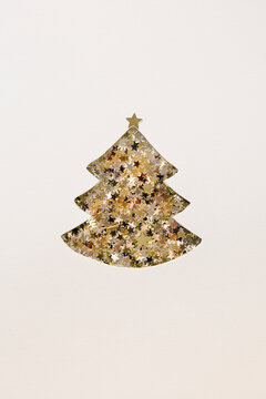 Pine tree for Christmas cut out of paper with little stars beneath it on a plain background