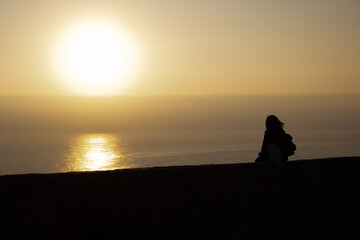 Silhouette of a woman watching the sunset