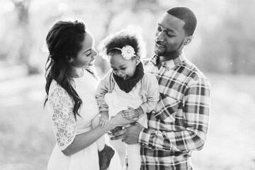 A family of three enjoying a beautiful day in the park.