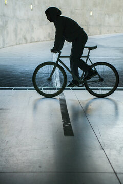 Silhouette of man driving bike.