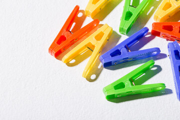 Colorful plastic clothespins for hanging clothes on white background