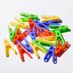 Colorful plastic clothespins for hanging clothes on white background