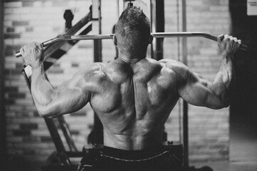 Male bodybuilder lifting weights in gym