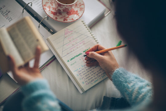 Young Woman Studying and Writing in a Notebook