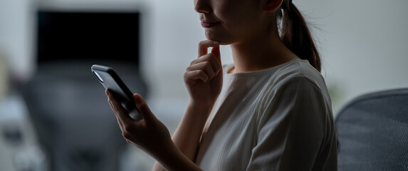 スマートフォンを見て考える女性