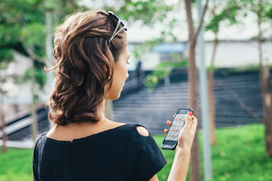 Young Pretty Businesswoman Looking at Sales Stats on Mobile Phone