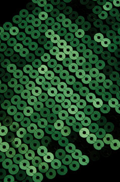 closeup macro of green sequins on black cloth