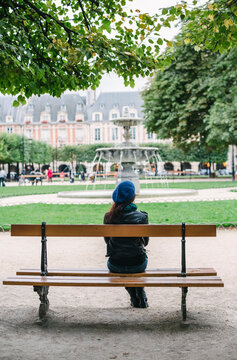 Young woman sitting on a bench in Paris
