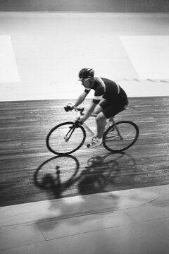 Black and white image of a track cyclist going fast