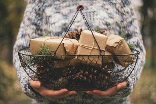 Woman holding basket full of rustic Christmas presents