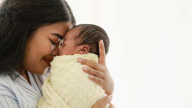 mixed race african american and asian mother holding newborn baby